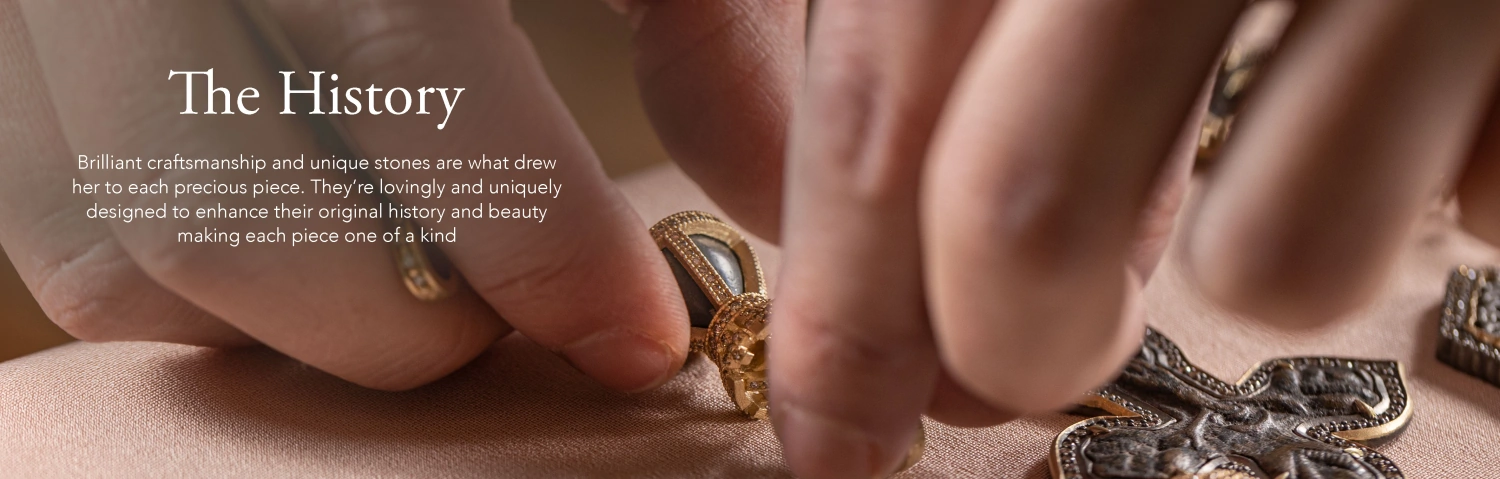 Image of Up-close photo of a craftsman working with antique crosses and pendants